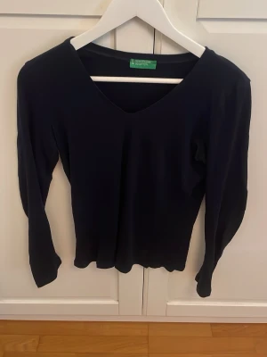 Marinblå  långärmad v-ringad topp - En stilren marinblå långärmad topp med v-ringning. Perfekt att matcha med jeans eller kjol för en enkel men snygg look. Tunn och mjuk i materialet, passar året runt. Den är i otroligt bra skick och den är från ett kvalité märke, jag köpte den för 300kr i vintras i barcelona.