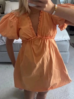 Orange klänning me puff ärm - Säljer min otroligt snygga klänning då den inte kommer till användning, perfekt för tillställningar!