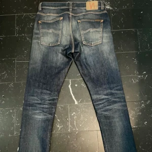 Nudie Lean Dean - Märke & Modell: Nudie, Lean Dean Storlek: W32 L34 (Passar S/M) Passform: Slim Skick: 9,5/10 Om plagget: Sanslöst feta Lean Deans i gråblå färg med orange stitching och benvita bakfickor, sjukt snygg tvätt och i perfekt skick. Info: 100% äkta | Postas inom 24h | Skriv vid frågor eller önskemål om fler bilder! 👖