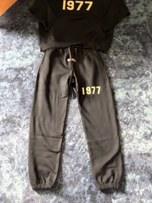 Essentials 1977 tracksuit - helt ny aldrig använd, svart med 1977 logo på sidan av benet och mitten av hoodien 