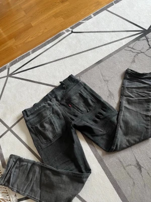 Levis 512 Slim Taper - Säljer ett par svarta jeans med klassisk femficksmodell och raka ben. Jeansen har en diskret tvättad look och silverfärgade nitar vid fickorna. Passar perfekt till en avslappnad stil och är tillverkade i denim.