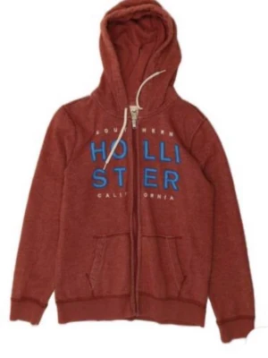 Röd hoodie från Hollister med tryck - Snygg röd hoodie från Hollister med blått tryck på bröstet och texten 'Southern California'. Dragkedja framtill, två fickor och justerbar huva med vita snören. Perfekt för en avslappnad och cool stil. Pris går att diskutera!!