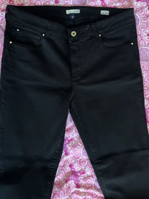 Svarta slim fit jeans - Snygga svarta slim fit jeans från Pepper Jeans med klassisk femficksdesign. Jeansen har normalhög midja och är tillverkade i ett stretchigt material för extra komfort. Perfekta till alla dina favoritoutfits! Den är helt ny men saknar prislapp! Aldrig använd