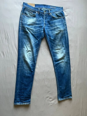 Dondup - Snygga blå jeans med raka ben och slitna detaljer på fram- och baksida. Klassisk femficksmodell med ljusare partier och kontrastsömmar. Perfekta för en avslappnad och trendig look.