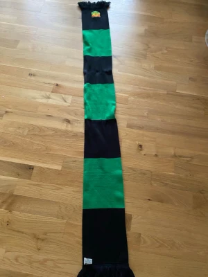 Grön svart GAIS halsduk - Lång halsduk med Gais loggan och grönsvarta ränder. Den köptes på en match och har inte använts sedan dess.