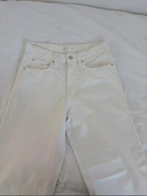Vita raka jeans från Perfect Jeans - Säljer ett par vita jeans från Perfect Jeans i rak modell. Jeansen har klassisk femficksdesign, bälteshällor och silverfärgade nitar och knapp. Materialet är denim i bomull och de har hög midja. Perfekta för en clean och stilren look.
