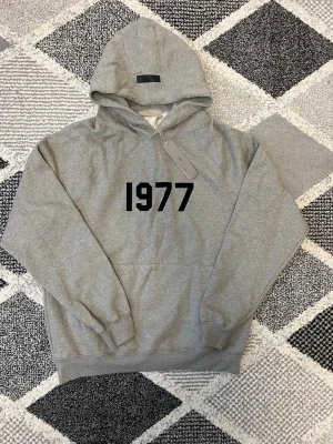 Essentials hoodie - Essentials 1977 hoodie som endast är testad och i väldigt fint skick. Säljs eftersom den tyvärr var för stor för mig. Har bara provats, annars inte använd.