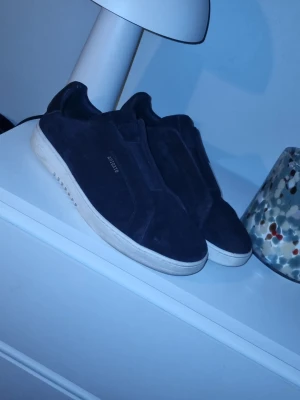 Axel arigato navy laceless - Stilrena skor från ARKET 🤍✨  Säljer mina Arigato laceless – sjukt clean design och passar till allt 👟🔥 Perfekta om du gillar minimalistisk stil men ändå vill sticka ut lite 😮‍🔥  ✔️ Bekväma hela dagen ✔️ Lättmatchade (funkar till både jeans & kostymbyxor) ✔️ relativt bra skick!   Storlek: 46 Pris: 999kr💸 (kan diskuteras vid snabb affär)  DM vid intresse! 📩 Först till kvarn 🚀 skickar med något extra i paketet 😉