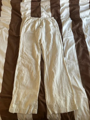 Vida linnebyxor i beige - Säljer ett par snygga, vida linnebyxor i beige med resår i midjan. Byxorna har en avslappnad passform och är perfekta för en chill och trendig look. Tillverkade i luftigt linnematerial som känns skönt mot huden. Från madlady använda 1 gång storlek xs-tall.
