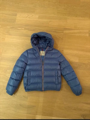Blå moncler vinterjacka  - En blå moncler vinterjacka i storlek 14 år/164. Nypris:8200. Köpt på NK. Väldigt bra skick. Sprsamt använd.