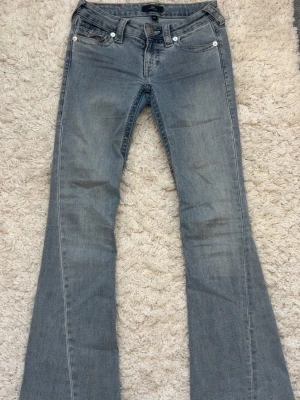 Ljusblå True religion Jeans- Joey low Rise flare🤍 - Säljer dessa superfina True Religion-jeans i modellen Joey Low Rise Flare, storlek 24. De är aldrig använda och är därför i helt nyskick. Inga slitningar, fläckar eller andra skador – säljs då de inte kommer till användning.  • Modell: Joey Low Rise Flare • Storlek: 24 • Färg: Ljusblå denim • Skick: Aldrig använda / nyskick • Äkta True Religion med den klassiska hästskosömmen och detaljerna på fickorna 🤍