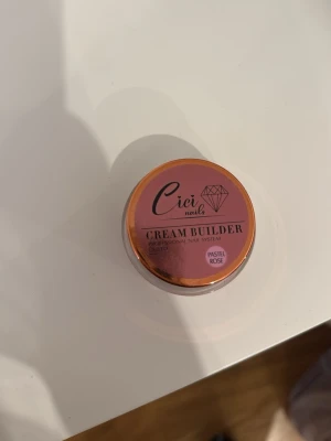 Cici Nails Cream Builder Pastel Rose - Bygggel för naglar i färgen Pastel Rose från Cici Nails. Kommer i en liten rund burk med skruvlock. Gelen har en mjuk rosa nyans och är perfekt för att skapa snygga och hållbara nagelförlängningar eller förstärkningar. 15g