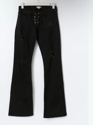 Svarta bootcut jeans med snörning - Säljer ett par svarta bootcut jeans med snörning och metallöljetter i midjan. Jeansen har slitna detaljer på låren och fickor fram. Perfekta för dig som gillar en edgy och trendig stil.