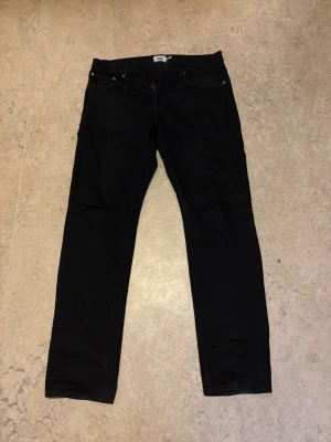 Svarta raka jeans - Svarta jeans med rak passform och klassisk femficksdesign. Jeansen har normal midja och stängs med dragkedja och knapp. Perfekta för en stilren och enkel look. Bredd och längd 32