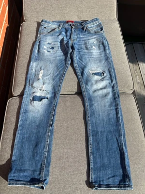 Jack and Jones jeans - Ett par riktigt feta jeans från Jack and Jones. Med feta slitningar och fades på låren. Modellen är slim/glenn. Storlek W30L32. Har inte så mycket att säga förutom att de är feta men.    Hör gärna av er om ni vill ha mått eller om ni har några frågor!