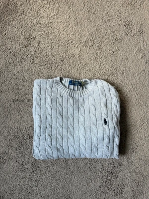 Ljusgrå kabelstickad tröja Polo Ralph Lauren - Hej ! Säljer nu denna kabelstickade tröjan från polo Ralph Lauren. Perfekt nu till hösten, storlek S, använd 1-2 gånger. Vid mer frågor eller funderingar tveka inte på att höra av dig mvh ☺️