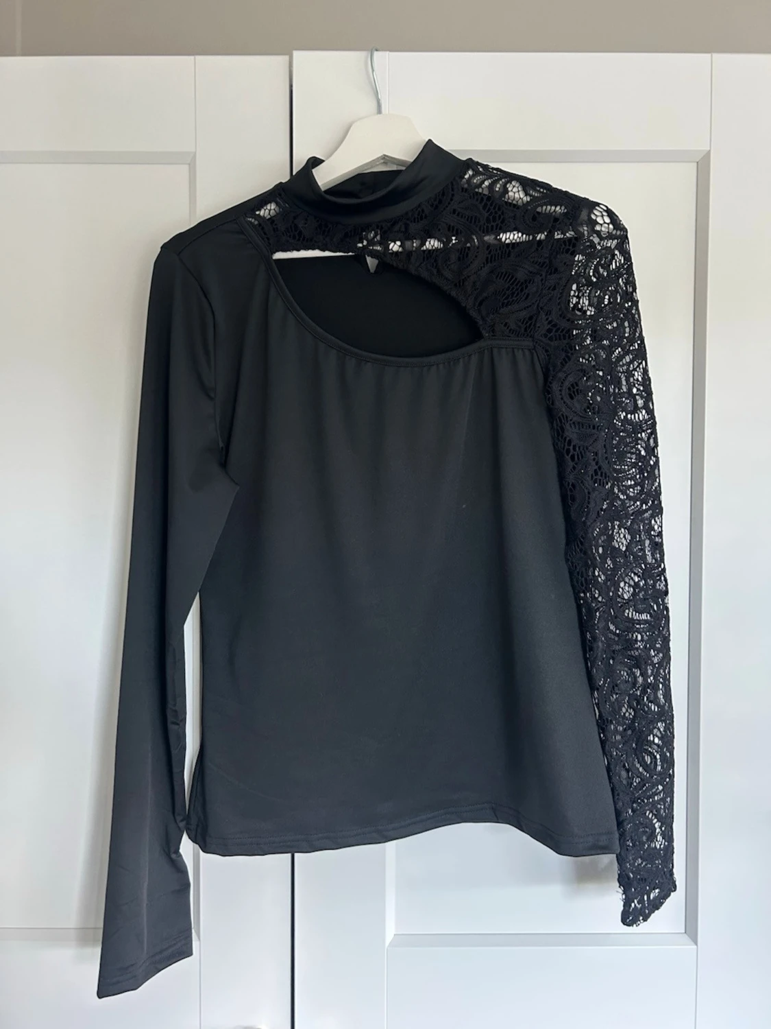 Svart topp med spets och cut out-detalj