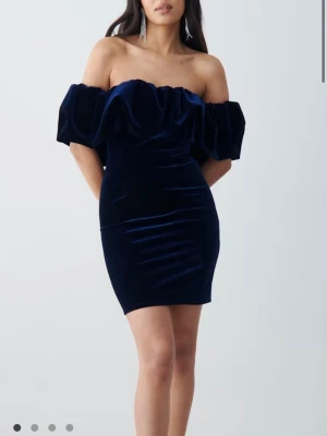 Volangklänning - Jättefin mörkblå off shoulder klänning med volang i sammet-liknande material från Gina Tricot i storlek M. Endast använd en gång, säljer då den inte passar längre tyvärr💕