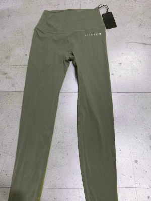 Gröna leggings från Relode - Snygga olivgröna leggings från Relode med hög midja och tight passform. Tillverkade i ett stretchigt material som sitter skönt mot kroppen. Perfekta för träning eller chill. Diskret logga på höften och långa ben. (PRIS LAPP KVAR)