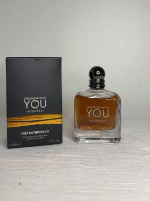 Stronger With You Intensely parfym - Stronger With You Intensely från Emporio Armani är en elegant herrparfym i en stilren, fyrkantig glasflaska med svart rund kork. Doften har en varm bärnstensfärg och kommer i en svart kartong med guldiga detaljer. Flaskan rymmer 100 ml eau de parfum.
