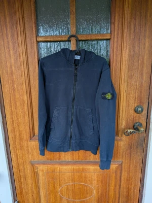 Stone Island zip hoodie - Tjena! Jag säljer en riktigt snygg Stone Island zip hoodie😁 Den är i mycket bra skick och har inga defekter! Den är självklart äkta✅ Skicka om du har några frågor☺️ Storlek 156 men stor i storlek passar ca xs!