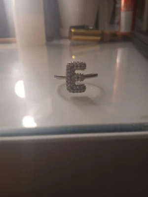 Ring med bokstaven E🥰 - Nästan aldrig använd och är justerbar! Bilderna är från förra ägaren då jag köpte den här på plick!!❣️
