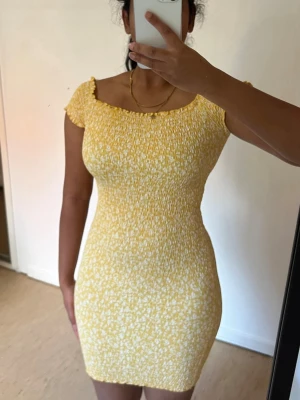 Gul blommig klänning från gina tricot  - Söt gul kortklänning med små vita blommor och smockad överdel. Klänningen har korta Superfin gul smockad klänning från Gina Tricot i storlek XS💛🌼 En feminin och somrig klänning i gul/mustard med små vita blommor, med smockad/stretchig kvalitet som formar sig fint efter kroppen.  ✨ Märke: Gina Tricot ✨ Storlek: XS ✨ Färg: Gul/guldgul med vita små blommor ✨ Passform: Stretchig och figurnära ✨ Detaljer: Smockad, blommigt mönster, volangkant ✨ Perfekt till semester, midsommar, dejt, brunch eller som
