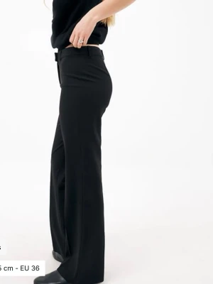 Svarta utsvängda kostymbyxor - Snygga svarta kostymbyxor med raka ben och medelhög midja. Perfekta för en stilren look och passar till många olika outfits. Aldrig använda innan!