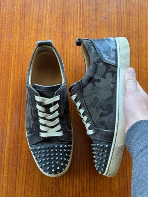Christian Louboutin Louis Junior Spikes Camoflauge - Säljer mina Christian Louboutin i storlek 44. Skorna är i okej skick och produceras inte längre. Allt og följer med (extra nitar, påsar, box). Var ej rädd för frågor. Skambud ignoreras!
