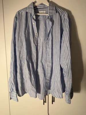 Blåvit randig skjorta eton - Säljer en snygg blåvit randig skjorta från Eton i slim fit. Skjortan har klassisk krage, knappar framtill och långa ärmar. Perfekt för dig som gillar stilrena och fräscha plagg. Materialet känns lätt och luftigt. Denna skjorta köptes för 2000kr men aldrig har använts.
