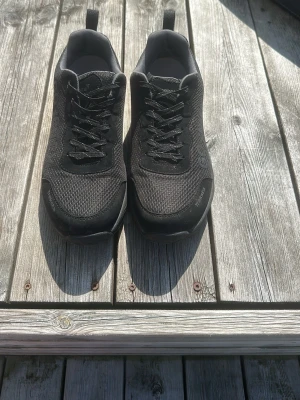 Svarta Gore-Tex sneakers från Treksta - Säljer ett par svarta sneakers från Treksta med Gore-Tex-material. Skorna har mesh- och syntetöverdel, klassisk snörning och diskret logga på sidan. Perfekta för dig som vill ha vattentäta och stilrena sneakers.