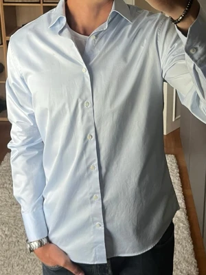 Stenströms skjorta i ljusblå - stl 40 (M) - Fitted body-passform i 100% bomull, twofold-vävd. Cutaway-krage, går lika bra till kostym som till jeans. Personen på bilden är 189cm, väger 78kg.  Använd men i mycket fint skick, inga hål eller fläckar.  Rök- och djurfritt hem. Skriv gärna om du vill ha fler bilder eller undrar något!