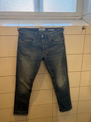 Blå raka jeans från Replay - Snygga blå jeans från Replay, modell Grover Straight Fit. Klassisk femficksdesign med gul kontrastsöm och diskret slitning på låren. Storlek- W30 L30