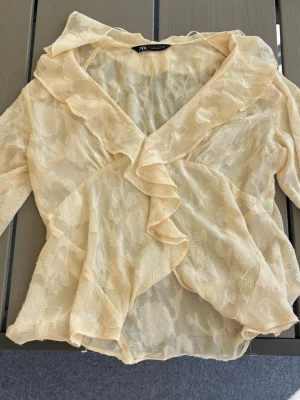 Beige volangblus med blommönster - Söt beige blus. Tunn och luftig i materialet, vilket ger en lätt och elegant känsla💕