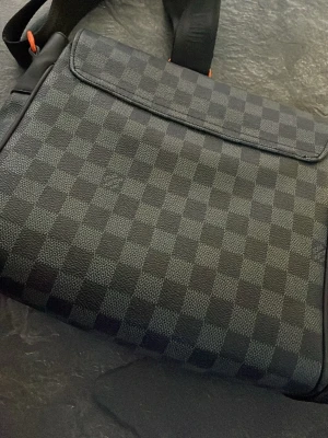 Svart väska med orange detaljer - Super snygg svart väska med orange detaljer, går att ha med sig överallt och är tillräckligt stor för att få plats med massor av grejer. Stilig är den också!