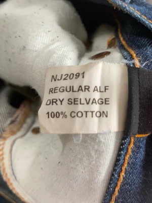 REGULAR ALF SELVAGE NUDIE JEANS - Ett par extremt snygga Nudie jeans, han på bilderna är 179. modell regular Alf, dry selvage, storlek 28/32 men skulle säga att den sitter mer som 29/32. Modellen är bootcut och discontinued, alltså säljs ej denna version längre. Dessa är i fint skick, inga defekter. På bild 5 ser ni ”selvage sömmen”. Har du några frågor? Fråga på