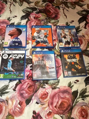 PS4 och PS5 spelpaket sport & action - Säljer ett paket med sex PlayStation-spel: FIFA 22, NHL 19, UFC 2, EA Sports FC 24, Battlefield 1 och Call of Duty Black Ops 4. Alla spel i blå plastfodral med färgstarka omslag. Perfekt för dig som gillar sport, action och shooters. 120 kr för allt men ni får kontakta om ni vill köpa enskilt.