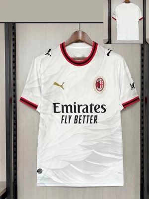 Vit AC Milan matchtröja Puma - Snygg vit AC Milan matchtröja från Puma med svart och röd krage och ärmslut. Tröjan har klubbmärke på bröstet, Puma-logga i guld och Emirates Fly Better-tryck framtill. Tillverkad i ett lätt och ventilerande material, perfekt för fotboll eller träning.