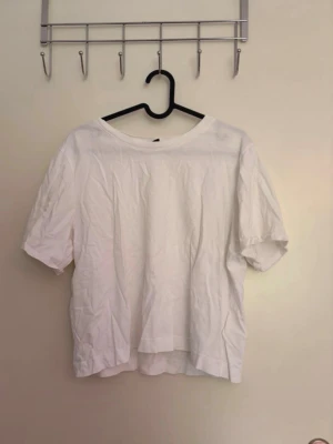 Vit basic t-shirt i bomull - En enkel vit t-shirt som är kort i modellen. Knappt använd