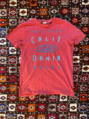 Unik Holister T-shirt  - Säljer en otroligt fet Holister T-shirt som är i grymt skick och har otroligt snygg, somrig färg! Storleken är M, som passar S också! Hör av dig vid frågor om tröjan osv! 