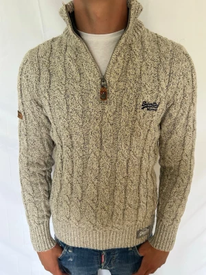Superdry tröja - Säljer denna tvärfeta stickade tröja ifrån Superdry. Modellen är ca 180 cm och väger 73 kg . Tveka inte på att kontakta mig vid minsta fundering🙌