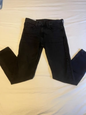 Svarta slim fit jeans från H&M - Säljer ett par svarta slim fit jeans från H&M. Jeansen har klassisk femficksdesign, normal midja och dragkedjegylf. Materialet är mjukt och stretchigt för en bekväm passform. Perfekta för en clean och stilren look.