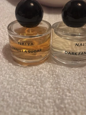 Fyra parfymer från Naiya - Säljer fyra olika parfymer från Naiya: Vanilla Sugar, Dark Fantasy, Spicy Vanilla och Honey Caramel. Flaskorna är runda i genomskinligt glas med svarta klotformade lock. Färgerna på vätskan varierar från klar till bärnstensfärgad. Perfekt för dig som gillar söta och kryddiga dofter.