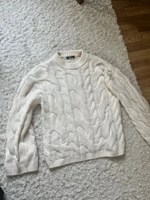 Vit kabelstickad tröja från Gina - Säljer en klassisk vit kabelstickad tröja från Gina i fint skick. Köpt i våras 