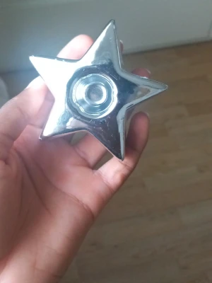 Silverfärgad stjärnformad ljushållare - En snygg stjärnformad ljushållare i blankt silverfärgat material, perfekt för värmeljus. Den har en modern och stilren design som passar som dekoration i hemmet.