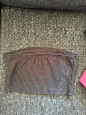 Mörkgrå tubtopp från SHEIN - Säljer en enkel och stilren mörkgrå tubtopp från SHEIN i stretchigt material. Toppen är axelbandslös och har en diskret struktur i tyget. Perfekt att matcha med jeans eller kjol för en clean look. Skriv privat för fler bilder eller om du har några frågor💗