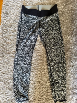 Svarta och vita mönstrade leggings - Säljer ett par leggings med svart och vitt abstrakt mönster och bred svart midjeresår. Tight passform och stretchigt material som passar perfekt till träning eller chill. Midjehöga och hel-långa ben. Snygga och bekväma för dig som gillar sportig stil. Skriv privat för fler bilder eller om du har några frågor💗