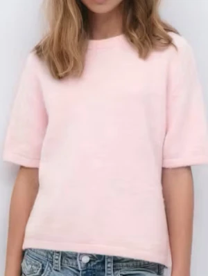 Ljusrosa stickad topp med kort ärm - Superfin ljusrosa stickad topp med korta ärmar och rund hals. Toppen har en mjuk och fluffig känsla, perfekt att styla med jeans eller kjol. Från Gina Young🩷