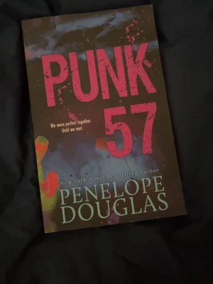 Punk 57 av Penelope Douglas - Punk 57 är en ungdomsroman av Penelope Douglas med ett färgstarkt omslag i svart, rosa och grönt. Boken har mjuka pärmar och titeln är tryckt i stora rosa bokstäver. Perfekt för dig som gillar romantik och drama.