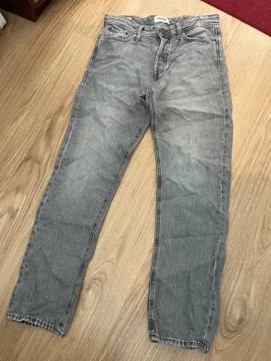 Jack&Jones jeans - Säljer ett par grå Jack&Jones jeans då de blivit för små i midjan. De är enligt mig väldigt snygga och passar bra till varje outfit. Skicket är faktiskt väldigt bra. Säljer de till ett bra pris med tanke på dess höga nypris!
